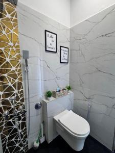 a bathroom with a toilet and a marble wall at Casa Oceanus - Sea Facing Forest View Room - Ganpatipule in Nevra