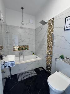 a bathroom with a tub and a toilet and a sink at Casa Oceanus - Sea Facing Forest View Room - Ganpatipule in Nevra