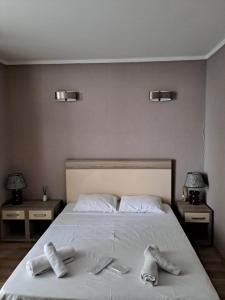 a bedroom with a bed with two pairs of shoes on it at BATUMi ORBI GRAND APART HOTEL in Batumi +24 photos