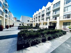 a courtyard of a large apartment building with plants at Surf & Stay - Muizenberg Beach in Muizenberg