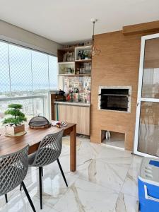 une cuisine avec une table en bois et deux chaises dans l'établissement Lindo apartamento 124C com vista mar e lazer de clube, à Guarujá