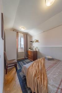 a bedroom with a bed and a chair and a window at Ada Home Belgrade Apartment  +15 photos