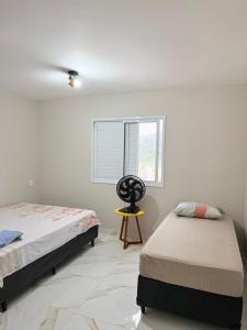 une chambre avec deux lits et une fenêtre dans l'établissement Lindo apartamento 124C com vista mar e lazer de clube, à Guarujá