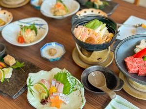 a wooden table with plates of food on it at Ryokan YUFUMOMIJI in Yufuin