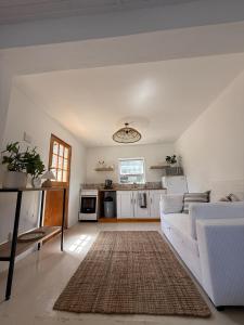 a living room with a white couch and a rug at Seaside Garden Cottage Schoenmakerskop in Gqeberha