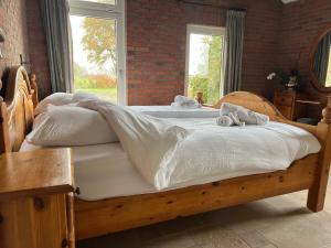 a bedroom with two beds with white sheets and a window at het Veenhuus in Nieuwlande