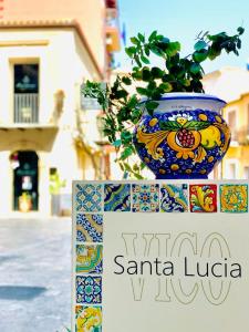 a vase sitting on top of a sign with a plant at Nicuzza in Gela +16 photos