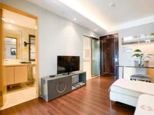 a living room with a television and a couch at Hesheng Hotel Apartment in Shenzhen