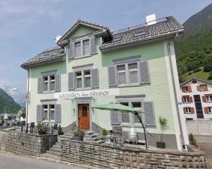 a green building with an umbrella in front of it at Gasthaus zum Freihof in Engi