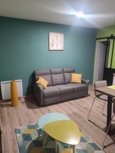 una sala de estar con un sofá y una mesa en Cosy F2 proche parc thermal VITTEL, en Vittel