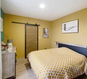 Un dormitorio con una cama y paredes amarillas. en Cosy F2 proche parc thermal VITTEL, en Vittel