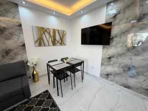 バヤイベにあるNEW - Maravilla Apartment Bayahibeのテーブルと壁掛けテレビのあるダイニングルーム