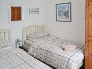two beds in a room with white walls at Summer Breeze in St Austell +11 photos