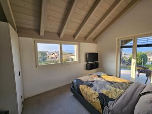 Un dormitorio con una cama y dos ventanas en Villa Tarca - Colico, Lake Como, en Colico