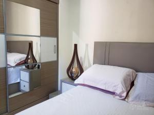 a bedroom with a white bed and a mirror at Casa de Madeira Encantadora in Governador Celso Ramos