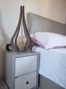 ゴヴェルナドール・セウソ・ラーモスにあるCasa de Madeira Encantadoraのベッド(ランプ付) +3枚の写真