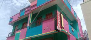 a multicolored building with a sign on the side of it at ACS New Cottage in Thiruchendur