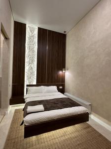 a bedroom with a large bed and a large window at The Palm hotel & spa in Almaty