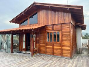 a wooden cabin with a glass door on a deck at Casa de Madeira Encantadora in Governador Celso Ramos