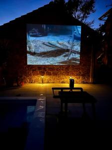 een tafel voor een scherm in een donkere kamer bij Villa 'Stone Garden' - Private Heated Pool & Outdoor Cinema in Trilj