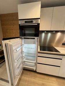 einem leeren Kühlschrank mit offener Tür in der Küche in der Unterkunft Le 1954 La Rosière in La Rosière