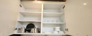a kitchen with white shelves and pots and pans at 수서역삼성병원대치동공항버스 in Seoul