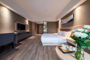 een hotelkamer met een bed en een tafel met bloemen bij Shengfeng Mingzuo Hotel in Hangzhou