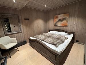 a bedroom with a bed and a chair in it at New modern cabin in Beitostølen in Beitostøl