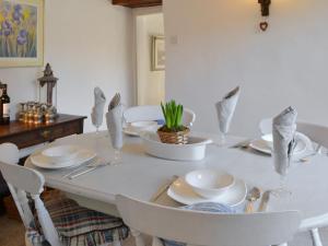 a white dining room table with white plates and chairs at Toad Hall in Helmsley +15 photos