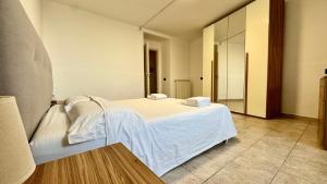 a bedroom with a white bed and a mirror at Fronte Mare Ampio Quadrilocale in Alassio