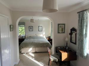 een slaapkamer met een bed, een bureau en een stoel bij Rectory House bed and breakfast in Danby Wiske