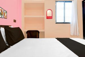 a bedroom with a bed and a window at Hotel O Welcome Guest House in Patna