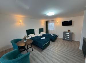 a hotel room with two beds and a tv at Rimuošės dvaras in Šniūraičiai