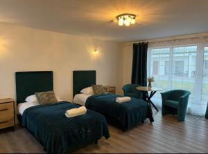 a bedroom with two beds and a table and chairs at Rimuošės dvaras in Šniūraičiai