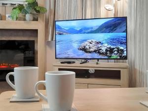 a living room with a flat screen tv and a fireplace at Graylings Rest - Uk35759 in Brigham