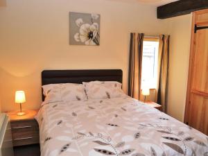 ein Schlafzimmer mit einem Bett mit einer Blume darauf in der Unterkunft Shepherds Cottage in Corney