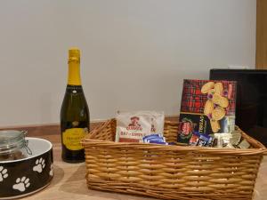 a basket of food and a bottle of wine on a table at Meadow View Cottage in Stanhope