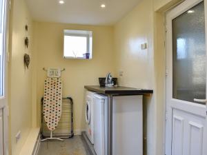 a laundry room with a washing machine and a window at Meadow View Cottage in Stanhope +12 photos