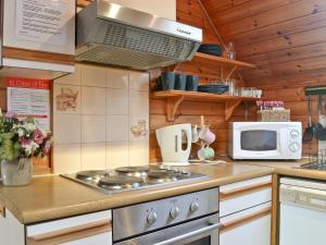 a kitchen with a stove and a microwave at Wee Ben in Bridge of Tilt