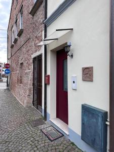 una porta rossa sul lato di un edificio di Casa Sorgata a Noale