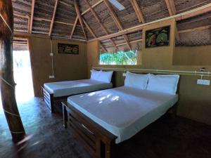 ein Schlafzimmer mit 2 Betten und einer Bank darin in der Unterkunft Thumbaya Resort Yala in Tissamaharama