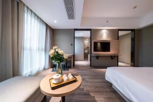 een hotelkamer met een bed en een tafel met bloemen bij Shengfeng Mingzuo Hotel in Hangzhou +14 foto's