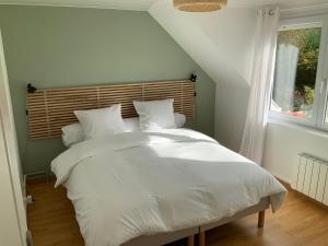 a bed with white sheets and pillows in a bedroom at Le sept in Ambleteuse