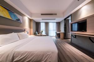 een hotelkamer met een groot bed en een flatscreen-tv bij Shengfeng Mingzuo Hotel in Hangzhou