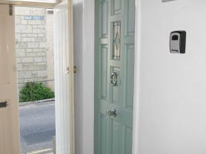 a green door in a room with a window at Salty Cottage in Newlyn