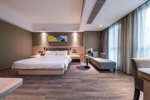 een hotelkamer met een groot bed en een bank bij Shengfeng Mingzuo Hotel in Hangzhou