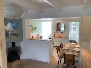 a kitchen and dining room with a table and a fireplace at Le sept in Ambleteuse