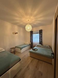 Un dormitorio con dos camas y una lámpara de araña. en Apartamenty Stronie - Polna Przystań, en Stronie Śląskie