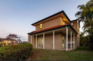 a house with a palm tree in front of it at Youth Castle in Brisbane