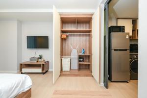 a room with a bed and a refrigerator and a desk at New Condo near Bangtao Beach - Space Cherngtalay in Ban Thalat Choeng Thale +5 photos